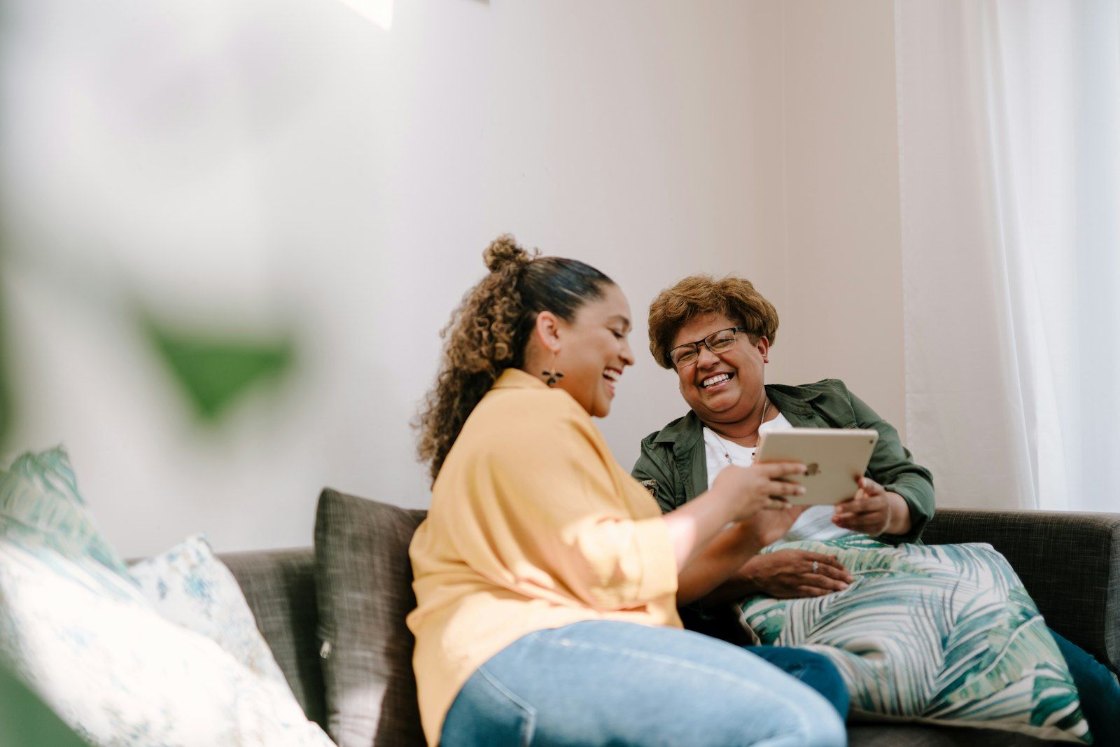Laughing together over a tablet at home.