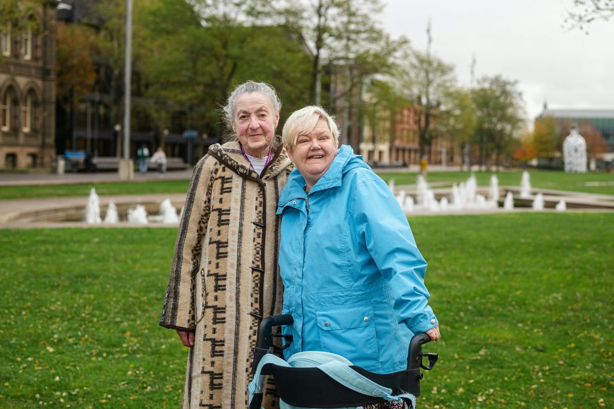 Two friends enjoying a walk in the park together.